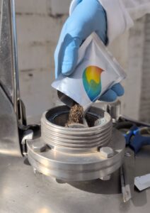manos humanas vertiendo un sobre de CMO® de Venpralab en un biodigestor